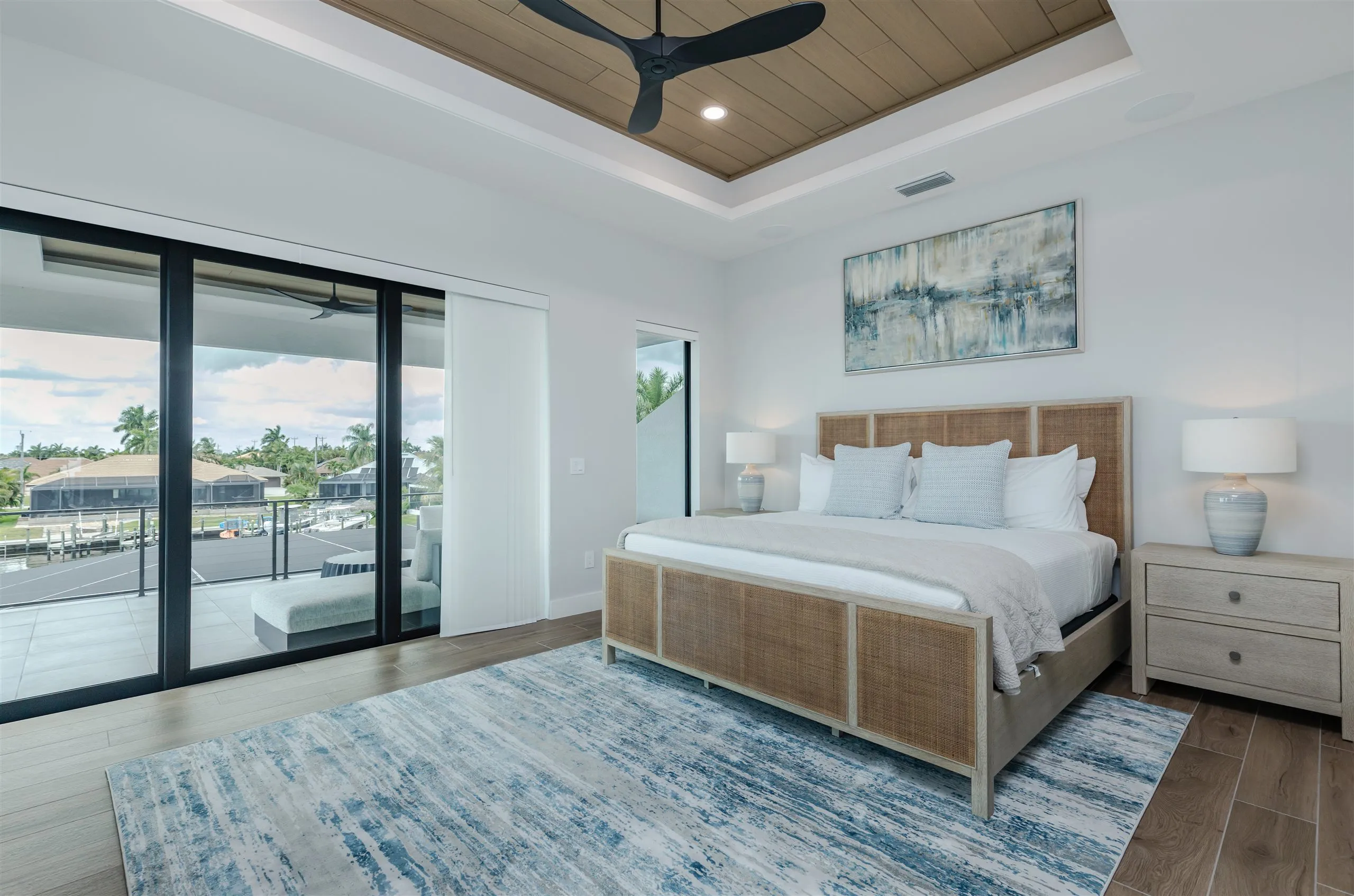 The primary waterfront suite at Villa Sauvage with balcony doors open to the canal