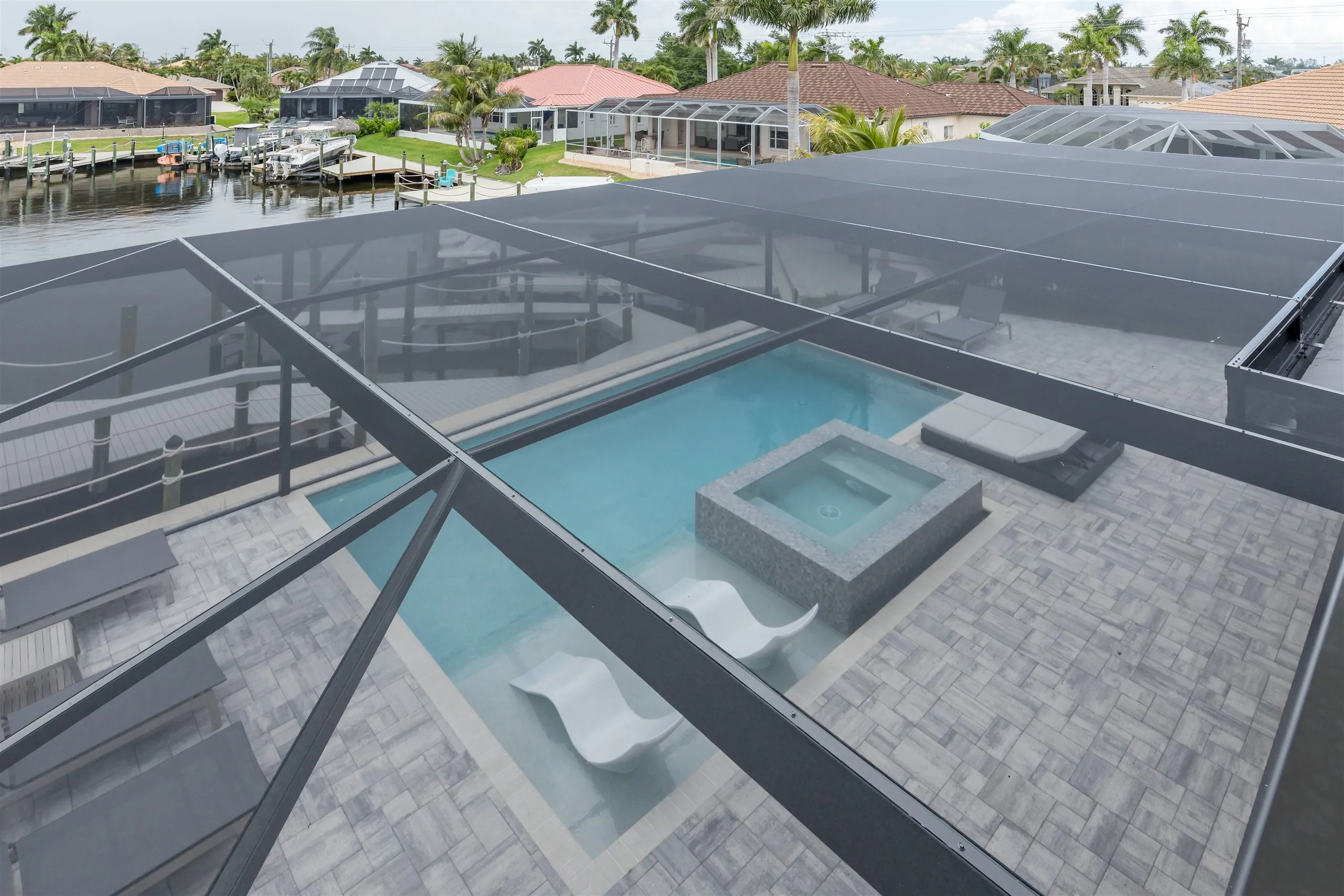 View over the pool enclosure toward the canal at Villa Sauvage